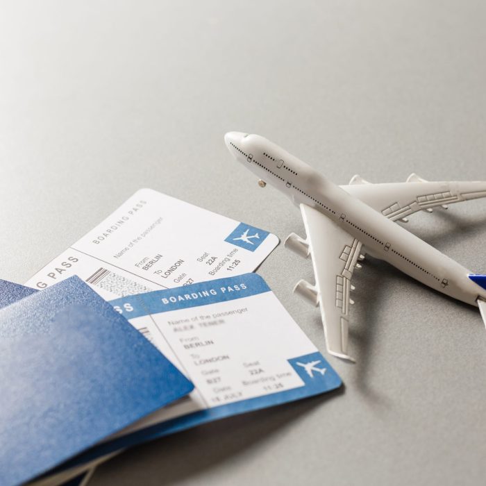 Flight tickets with passports, model of airplane, isolated on white background.